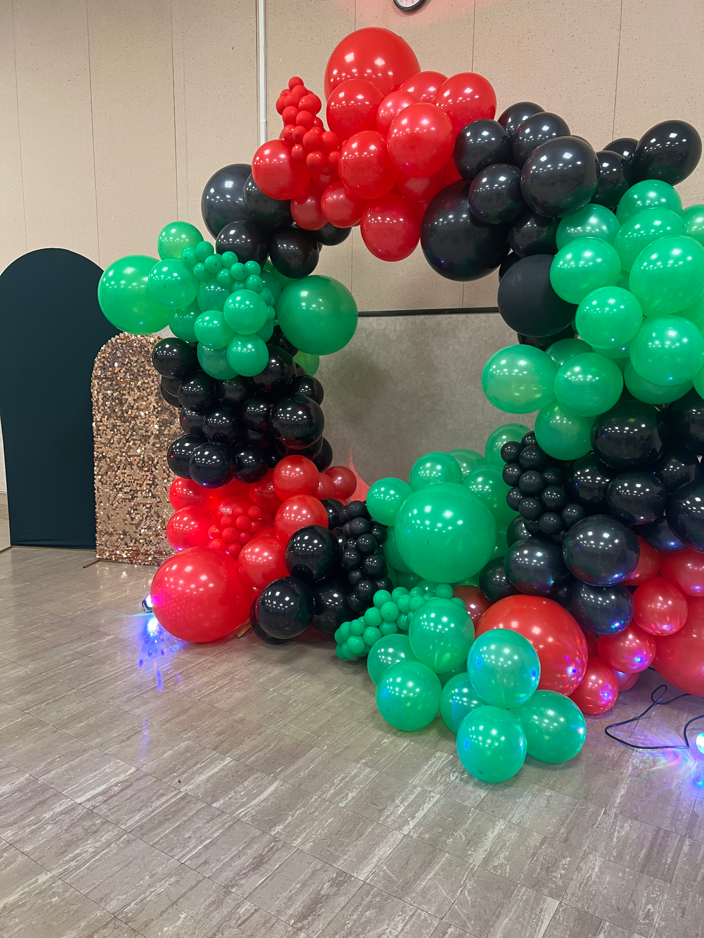 Red, black and green balloon circle arch