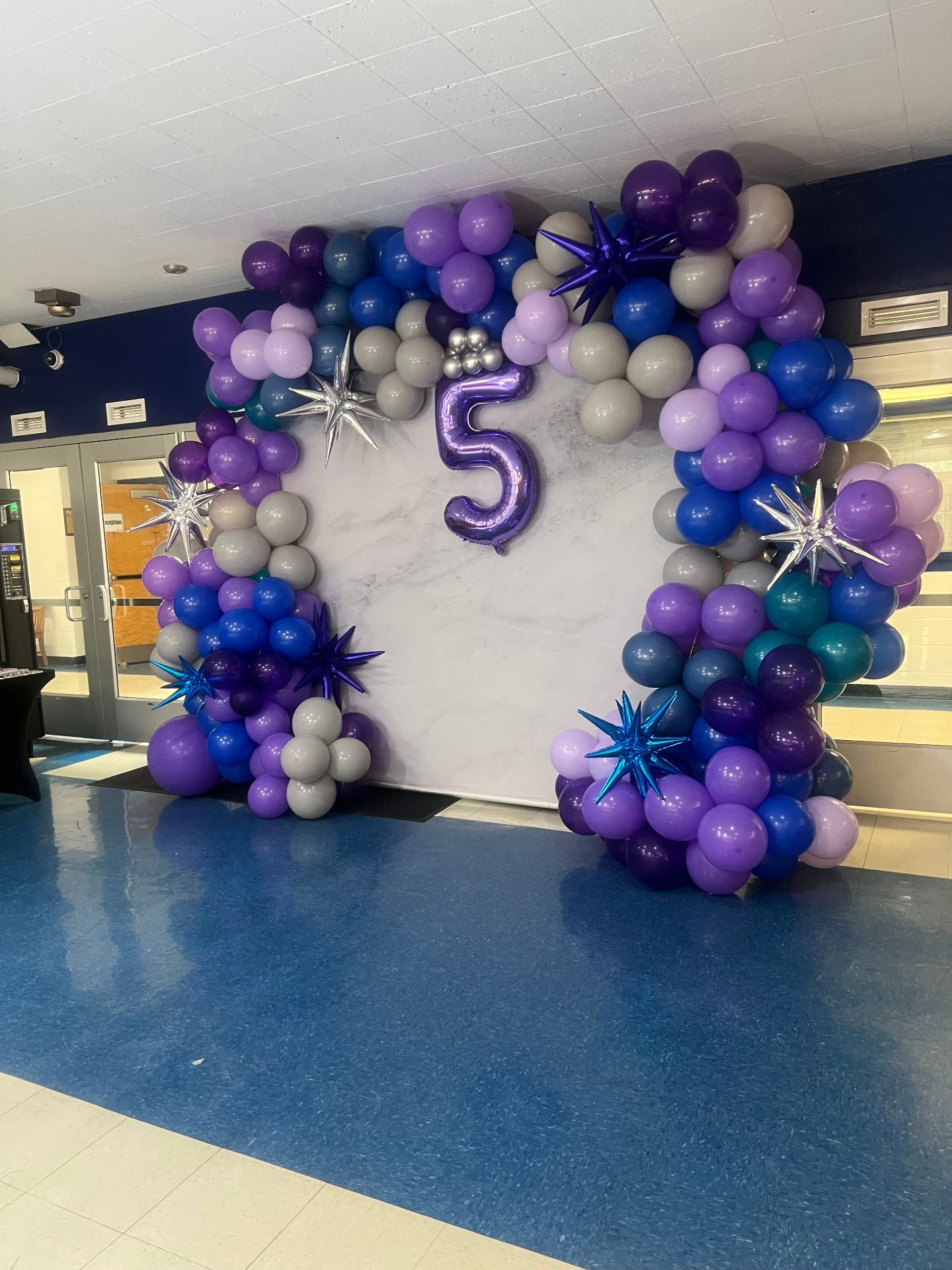 Purple and silver balloon arch with starburst accents
